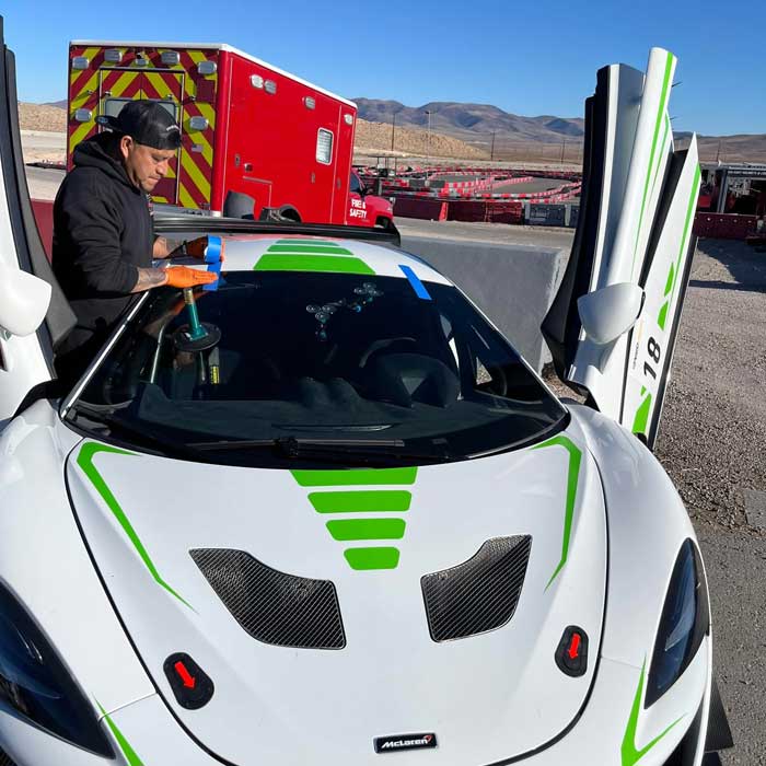 Technician working on performance vehicle windshield